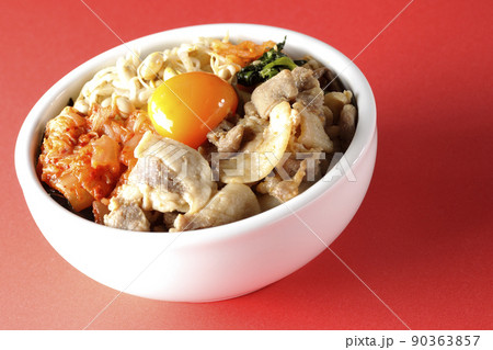 もやしナムルやキムチ、豚肉など沢山の具材が入っているビビンバ丼 90363857