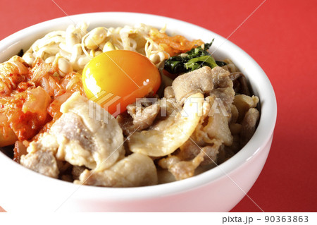もやしナムルやキムチ、豚肉など沢山の具材が入っているビビンバ丼 90363863