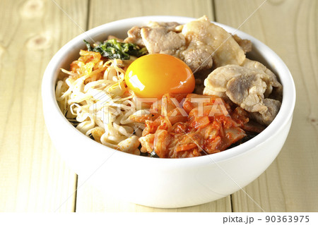 もやしナムルやキムチ、豚肉など沢山の具材が入っているビビンバ丼 90363975