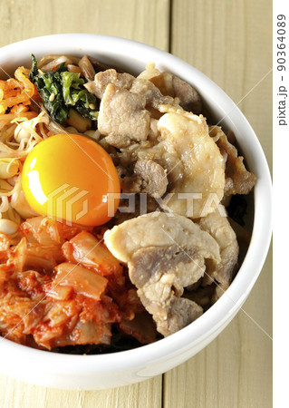 もやしナムルやキムチ、豚肉など沢山の具材が入っているビビンバ丼を俯瞰で撮影 90364089