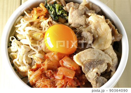 もやしナムルやキムチ、豚肉など沢山の具材が入っているビビンバ丼を俯瞰で撮影 90364090
