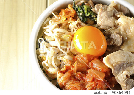 もやしナムルやキムチ、豚肉など沢山の具材が入っているビビンバ丼を俯瞰で撮影 90364091