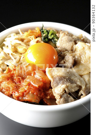 もやしナムルやキムチ、豚肉など沢山の具材が入っているビビンバ丼を黒背景で撮影 もやしナムルやキムチ、豚肉など沢山の具材が入っているビビンバ丼を黒背景で撮影 90364132
