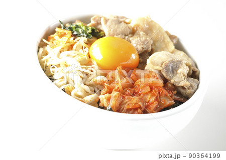 もやしナムルやキムチ、豚肉など沢山の具材が入っているビビンバ丼を白背景で撮影 90364199