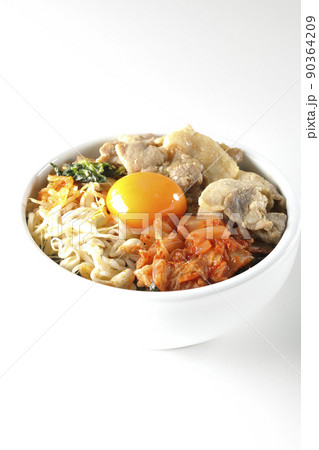 もやしナムルやキムチ、豚肉など沢山の具材が入っているビビンバ丼を白背景で撮影 90364209