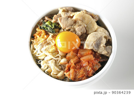 もやしナムルやキムチ、豚肉など沢山の具材が入っているビビンバ丼を白背景で俯瞰撮影 90364239