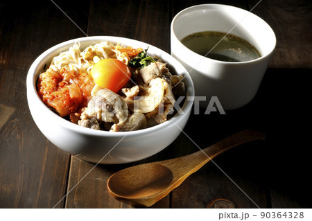 もやしナムルやキムチ、豚肉など沢山の具材が入っているビビンバ丼とわかめスープ 90364328