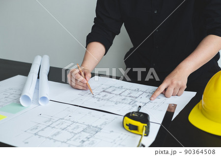 Architects or engineers working construction and drawing construction plans, printing, writing on-site construction sites. Home design concept Architects or engineers working construction and drawing construction plans, printing, writing on-site construction sites. Home design concept 90364508