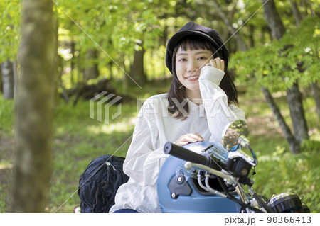 バイク女子イメージ　森の中でバイクにまたがる若い女性 90366413