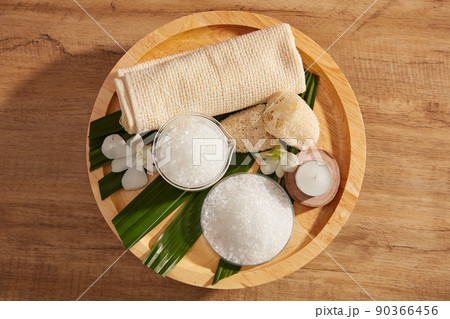 Close view of salt in spa decorated with towel and candles in wooden tray for exfoliating advertise , top view Close view of salt in spa decorated with towel and candles in wooden tray for exfoliating advertise , top view 90366456