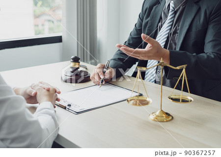 A man lawyer or a judge counseling clients about judicial justice and prosecution with scales, judges gavel, legal documents legal services concept 90367257