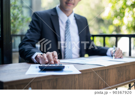 Young Asian businessman financial market analyst sits at their desks and calculate financial graphs showing the results of their investments planning the process of successful business growth 90367920