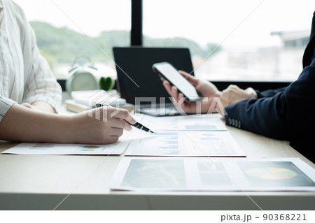 Two business leaders talk about charts, financial graphs showing results are analyzing and calculating planning strategies, business success building processes Two business leaders talk about charts, financial graphs showing results are analyzing and calculating planning strategies, business success building processes 90368221