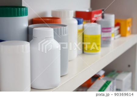 Bottles of pills arranged on shelf at drugstore 90369614