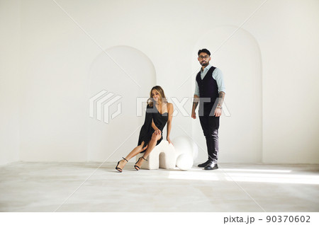 Stylish young ethnic couple embracing against light gray wall 90370602