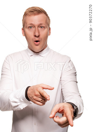 Imposing, young, blond man in a white shirt is grimacing while standing isolated on a white background 90372270