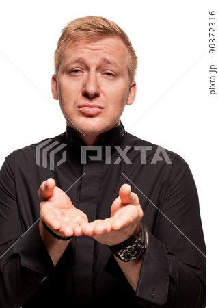 Young blond man in a black shirt, watches and bracelet is making faces, isolated on a white background 90372316