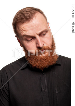 Portrait of a young, chubby, redheaded man in a black shirt making faces at the camera, isolated on a white background 90372350