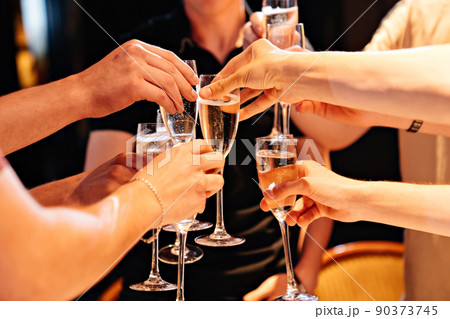 hands with glasses of champagne at the banquet. traditional toasts on holidays. hands with glasses of champagne at the banquet. traditional toasts on holidays. 90373745