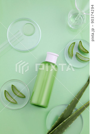 Background Green with natural cosmetics of aloe vera extract. Cosmetics on green table with aloe vera in petri, tube 90374294