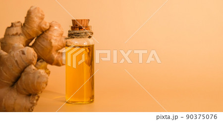 Glass bottle of essential ginger oil, ginger root on beige background. Healthy food eating concept. Zingiber officinale Essential oil. Natural cosmetics ingredients for skincare, body and hair care Glass bottle of essential ginger oil, ginger root on beige background. Healthy food eating concept. Zingiber officinale Essential oil. Natural cosmetics ingredients for skincare, body and hair care 90375076