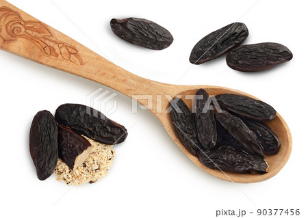 Tonka bean in wooden spoon isolated on white background with full depth of field. Bean of Dipteryx odorata. Top view. Flat lay 90377456
