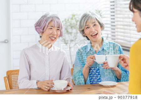 リビングでお茶を飲みながら会話するミドルエイジの女性3人 リビングでお茶を飲みながら会話するミドルエイジの女性3人 90377918