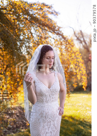 White Caucasian Adult Woman in a Wedding Dress standing outside in nature White Caucasian Adult Woman in a Wedding Dress standing outside in nature 90379578