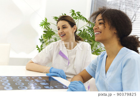 Focused worried multiethnic healthcare workers analyzing CT lung screening while working in medical clinic or hospital 90379825