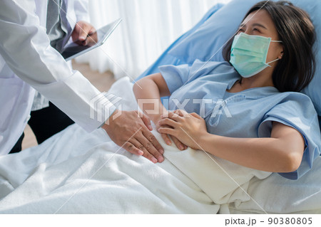 Group of Doctor try to help patient woman lie on hospital bed and holding on stomach suffering. Abdominal pain that comes from menstruation, diarrhea, or indigestion. Sickness and healthcare concept Group of Doctor try to help patient woman lie on hospital bed and holding on stomach suffering. Abdominal pain that comes from menstruation, diarrhea, or indigestion. Sickness and healthcare concept 90380805
