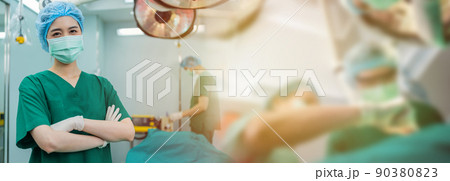 Portrait of Asian women surgeon and nurse with medical mask standing with arms crossed in operation theater at a hospital. Team of Professional surgeons. Healthcare, emergency medical service concept Portrait of Asian women surgeon and nurse with medical mask standing with arms crossed in operation theater at a hospital. Team of Professional surgeons. Healthcare, emergency medical service concept 90380823