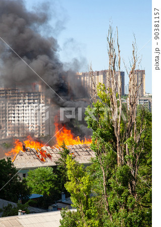 A fire in an old abandoned house, a view from the window of a neighboring high-rise building A fire in an old abandoned house, a view from the window of a neighboring high-rise building 90381157