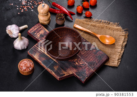 An empty plate with a knife, fork or spoon with a wooden cutting board An empty plate with a knife, fork or spoon with a wooden cutting board 90381553
