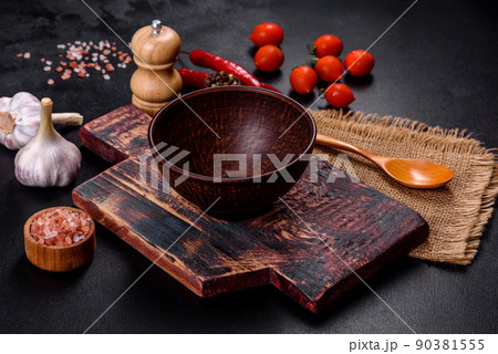 An empty plate with a knife, fork or spoon with a wooden cutting board An empty plate with a knife, fork or spoon with a wooden cutting board 90381555