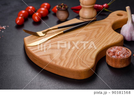 An empty plate with a knife, fork or spoon with a wooden cutting board An empty plate with a knife, fork or spoon with a wooden cutting board 90381568