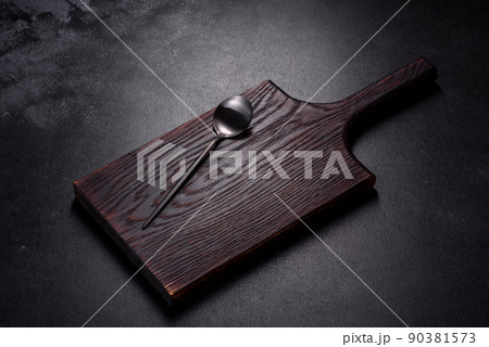 An empty plate with a knife, fork or spoon with a wooden cutting board An empty plate with a knife, fork or spoon with a wooden cutting board 90381573