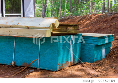 Stacker wooden material boards and beams for new house on of under construction 90382164