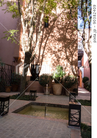 モロッコの街マラケッシュの赤茶色の建物と緑のあるホテルの中庭 90382409