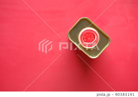 container of olive oil on red background top view  90383191