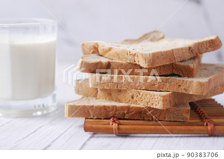 close up of stack of baked bread and glass of milk on table close up of stack of baked bread and glass of milk on table 90383706