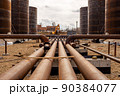 Oil refinery construction site with oil storage tanks in background. 90384077
