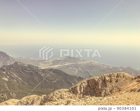 mountains against the blue sky. upland of stones and sand. grass and bushes grow on the mountain. leisure. hiking trails on the mountain, travel to hot countries 90384101