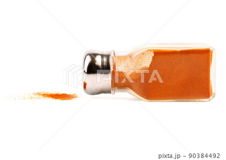 glass pepper pot with ground red pepper dropped on its side isolated on white background 90384492