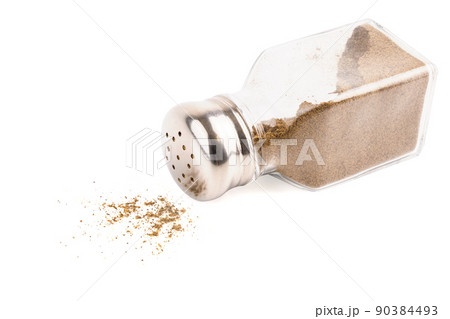 glass pepper pot with ground black pepper dropped on its side isolated on white background 90384493