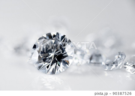 brilliant cut diamond held by tweezers on white background 90387526