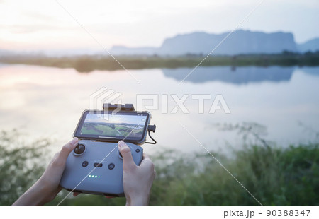hands using drone command radio for flying in evening time to take high view photo hands using drone command radio for flying in evening time to take high view photo 90388347