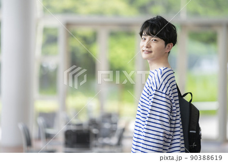 バックパックを持ったカメラ目線で笑顔の若い男性　 90388619