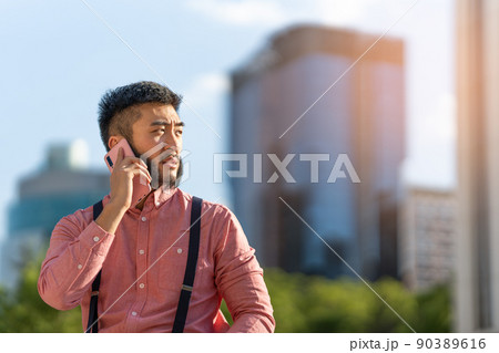 Asian businessman talking to the mobile outdoors 90389616