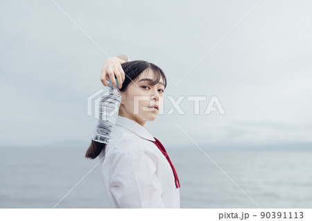 海辺で水を飲む女子高生 90391113