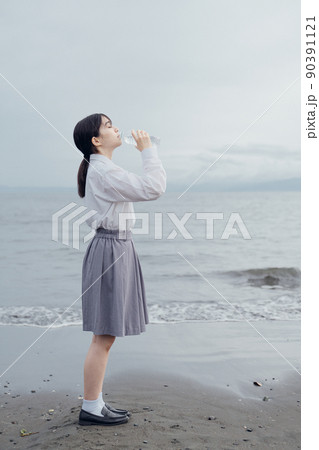 海辺で水を飲む女子高生 海辺で水を飲む女子高生 90391121